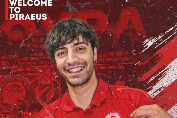 Smiling young man in a red polo shirt on a red sports poster background with Greek text and 'Olympiacos Onex Men's Volleyball Dept.'