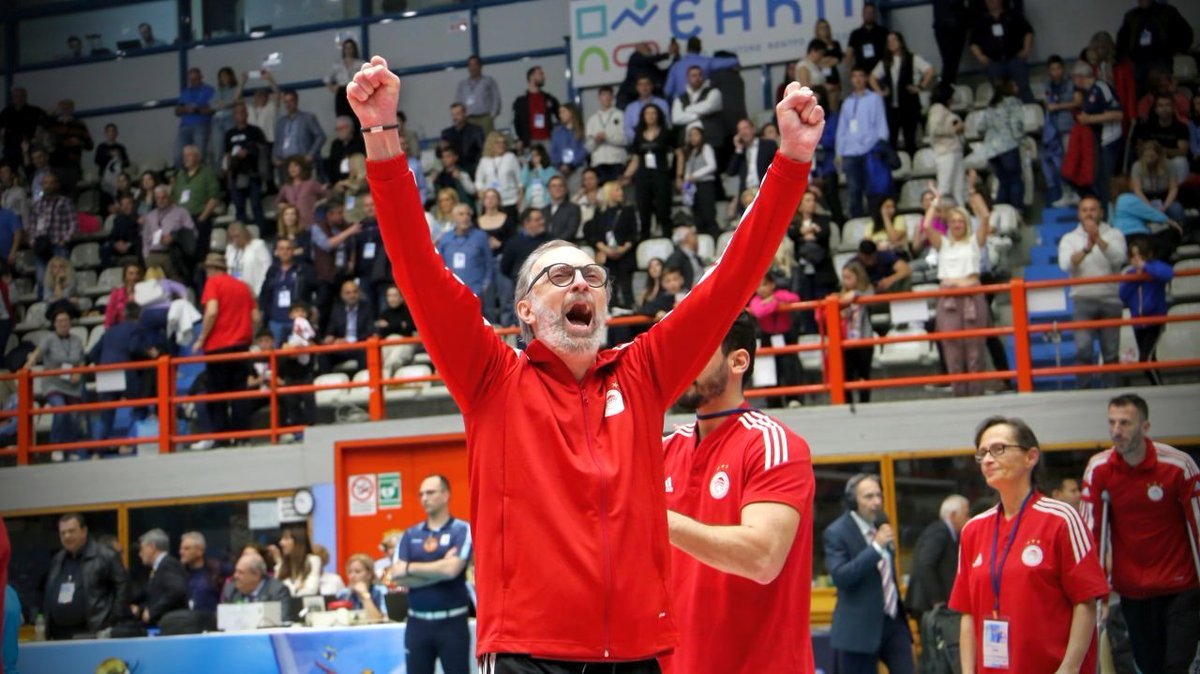 HLsbaMfW4AAGwdg The Volley Lovers Man in a red jacket raises both arms in triumph amid a cheering crowd at an indoor sports arena.