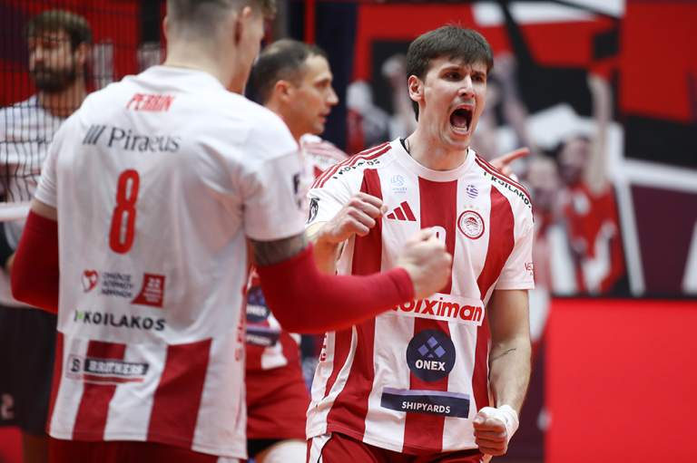 0000 The Volley Lovers Volleyball players in red-and-white striped uniforms celebrate a point, one shouting with clenched fists toward a teammate in the foreground.