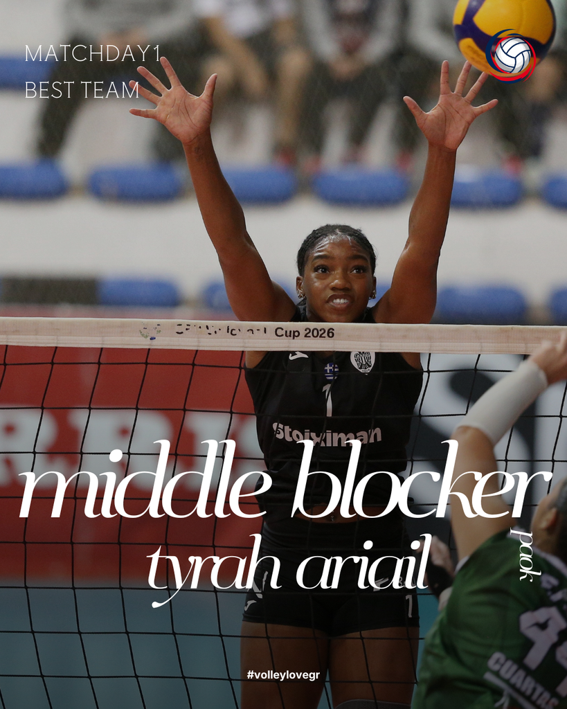 12 The Volley Lovers Female volleyball player in black uniform blocks at the net with hands raised during a match; volleyball visible at top right.