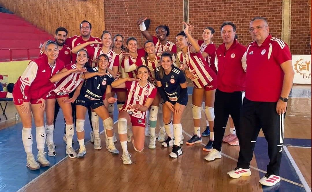 83993665614111615978868492829061798586455571n The Volley Lovers Women’s volleyball team posing together after a match, many in red-and-white striped uniforms in a gym. Coaches stand at right.